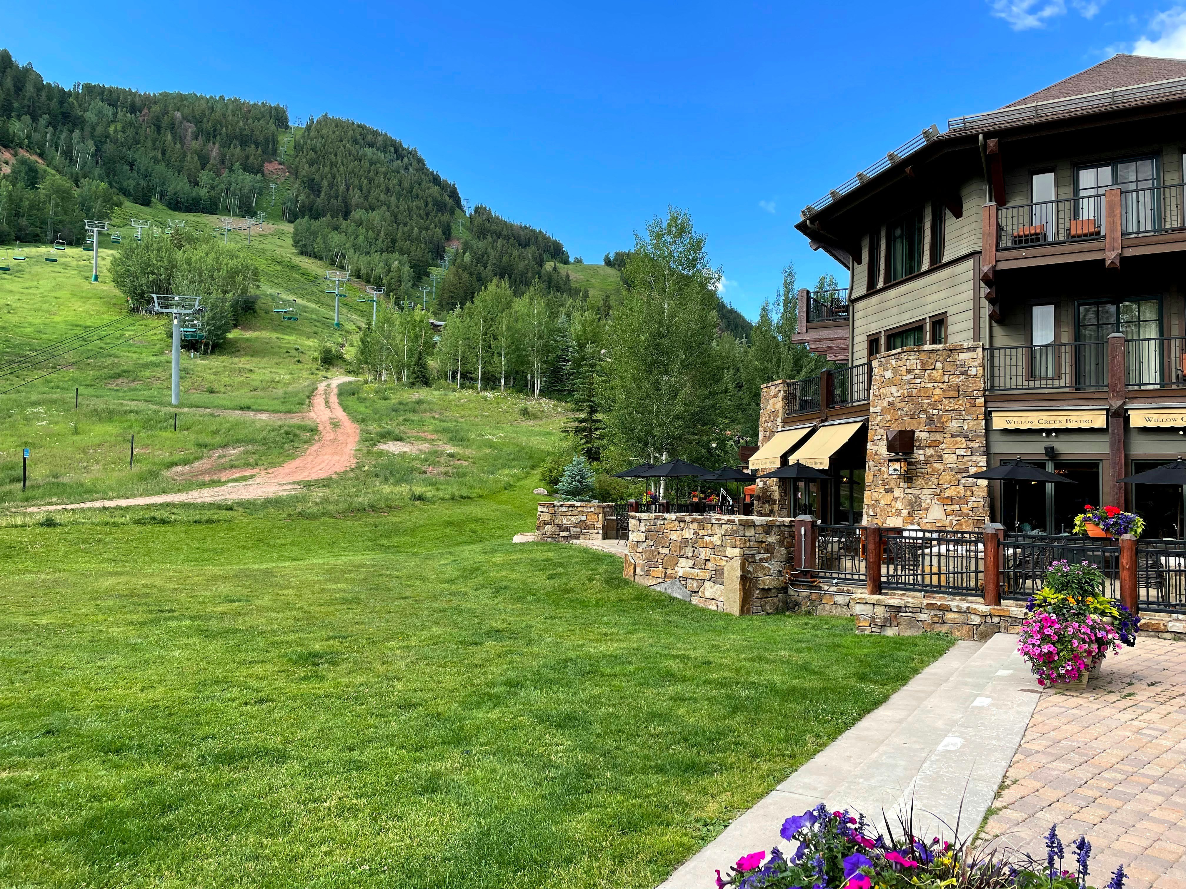 Vail village in summer with green slopes and stone lodge