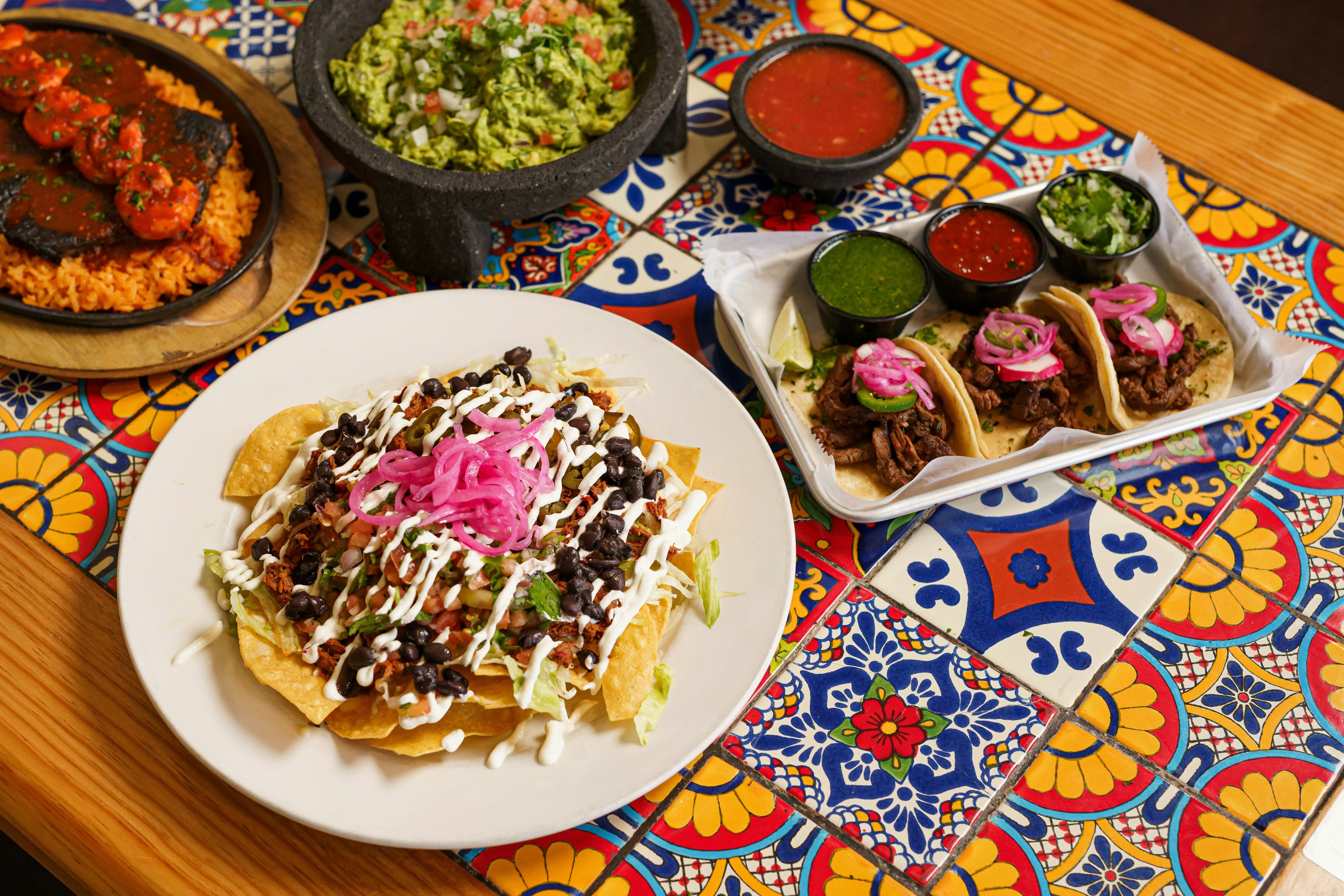 Colorful spread of Mexican tacos, guacamole and salsas
