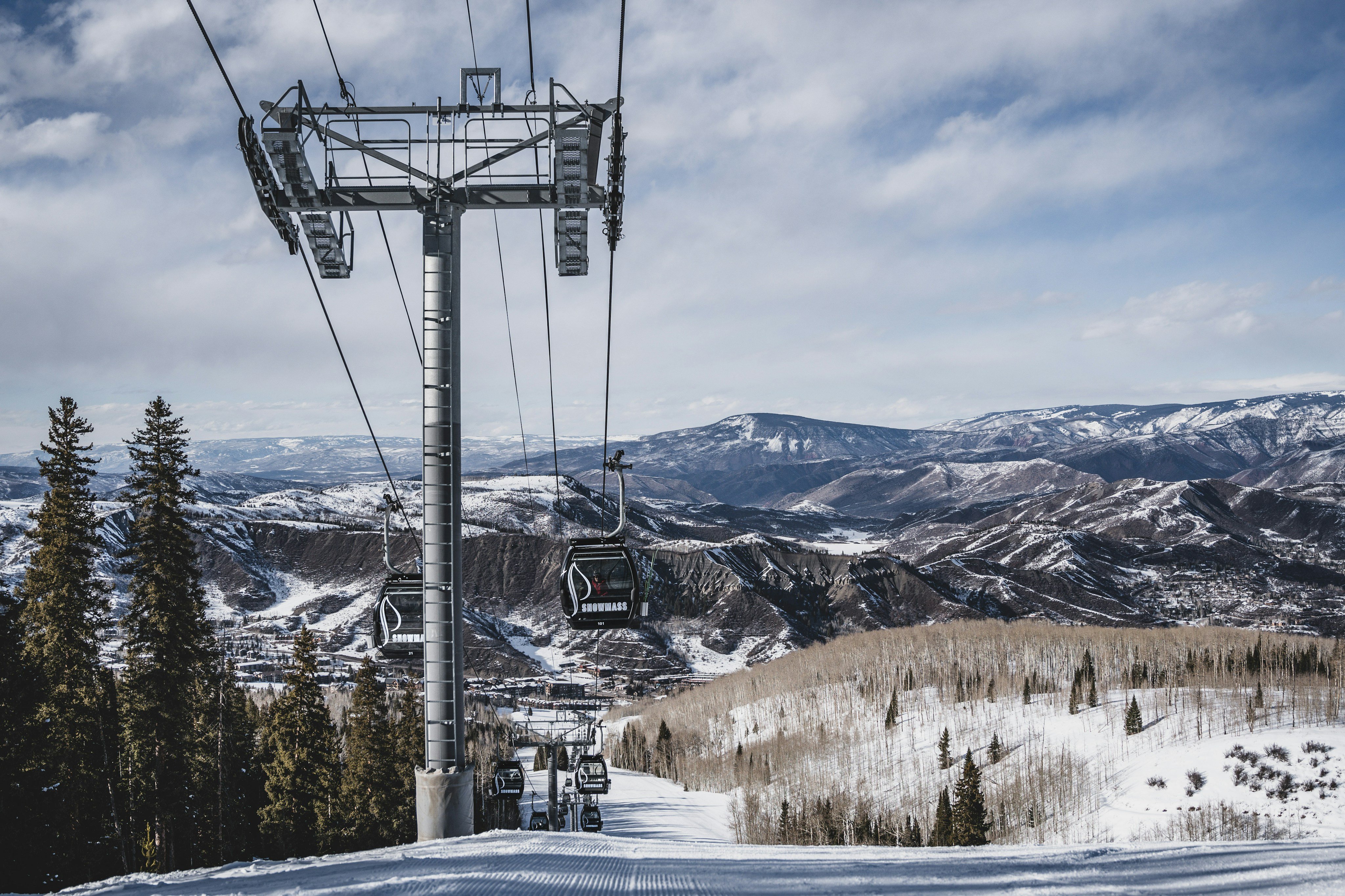 Ski lift chairs over a wide mountain valley